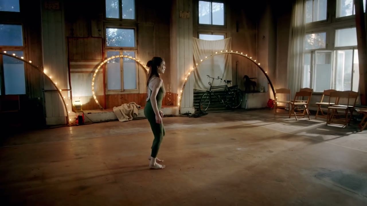 Tanz im Saal mit Lichterbögen vor hohen Fenstern