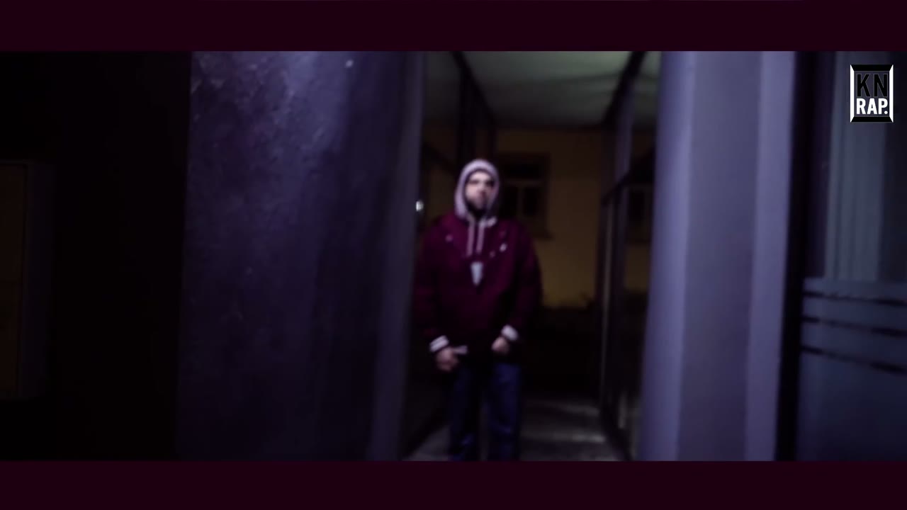LAZAR steht am Ende eines Gangs, gerahmt von zwei Wänden