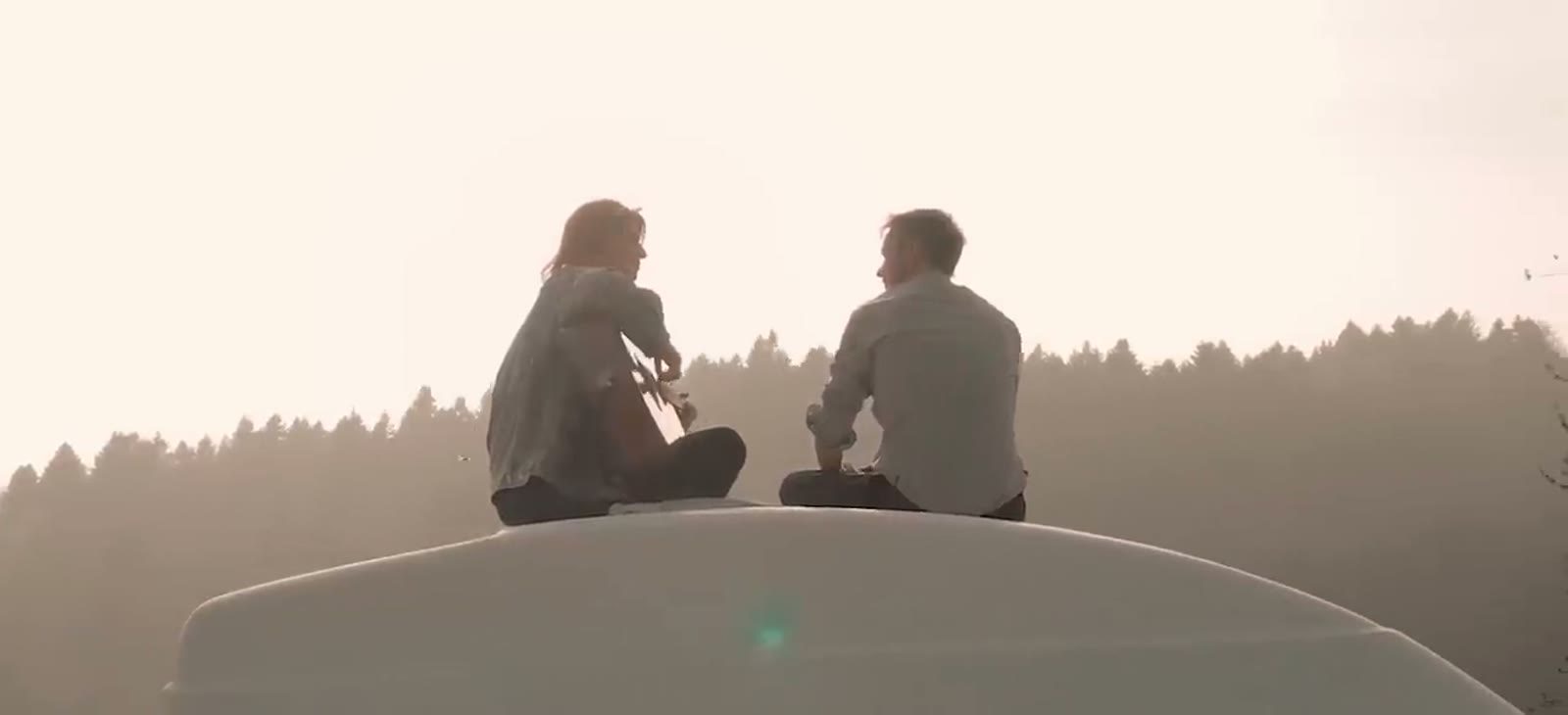 sameday – zwei Personen auf einem Autodach im Abendlicht