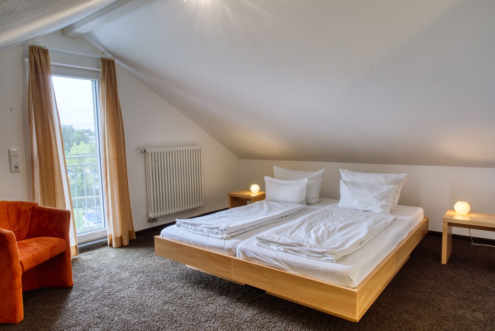 Zimmer unter der Dachschräge, zwei Nachttischleuchten, Balkontür