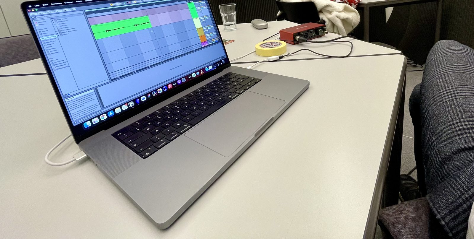 Aufnahmeplatz: Laptop mit geöffneter Audio-Software, daneben ein Audio-Interface, im Hintergrund Akustikabsorber