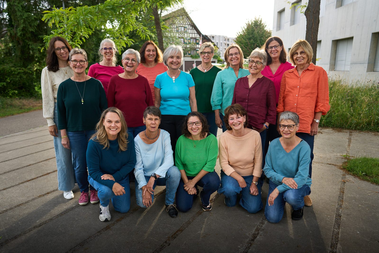 Gruppenbild: siebzehn Sängerinnen in zwei Reihen, vorne kniend, in bunten Oberteilen